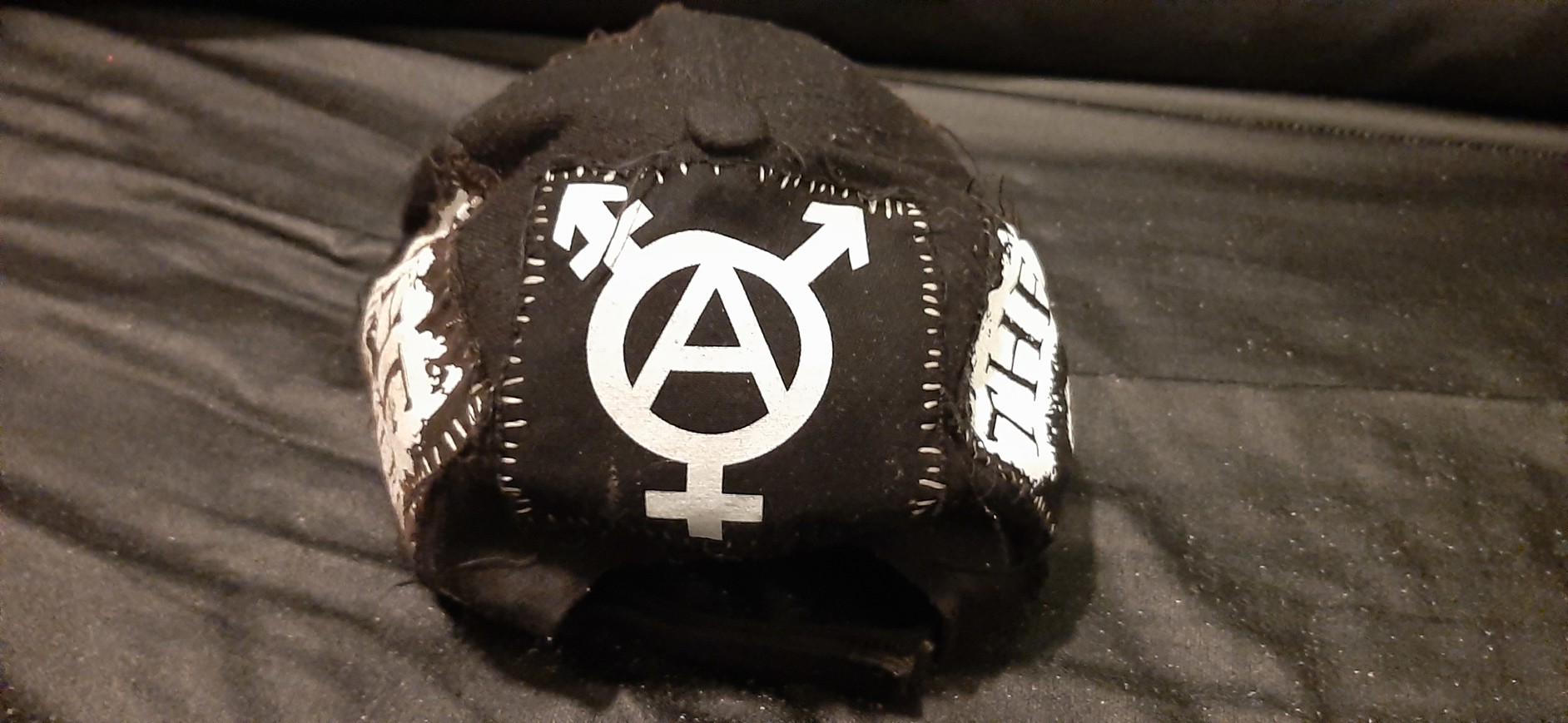 back of my DIY'd black gender terrorist hat, which is the tranarchy symbol patch'